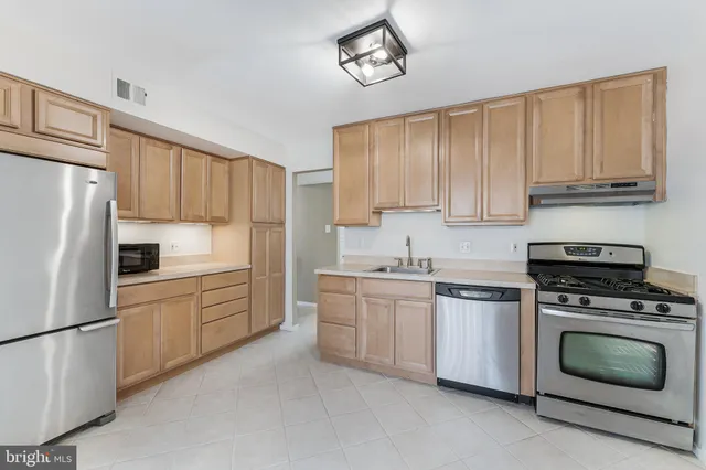 a kitchen with cabinets stainless steel appliances and a sink