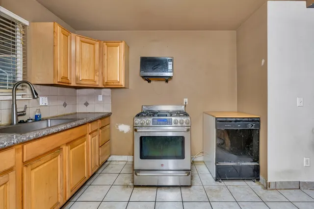a kitchen with stainless steel appliances granite countertop a sink and a stove