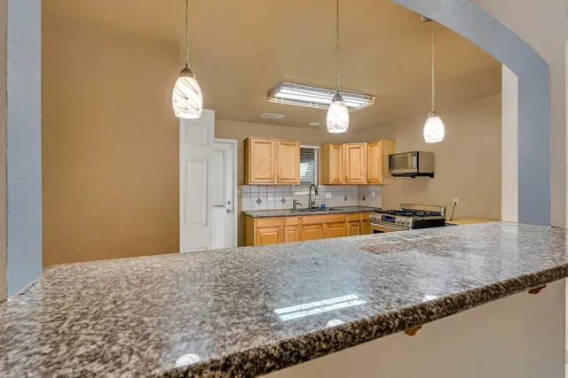 a view of a kitchen with granite countertop cabinets and a stainless steel appliances