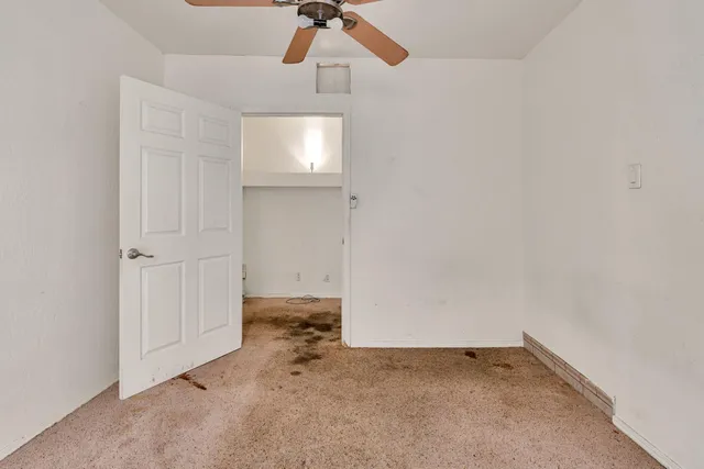 an empty room with a ceiling fan