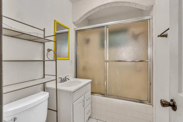 a bathroom with a shower sink vanity and toilet