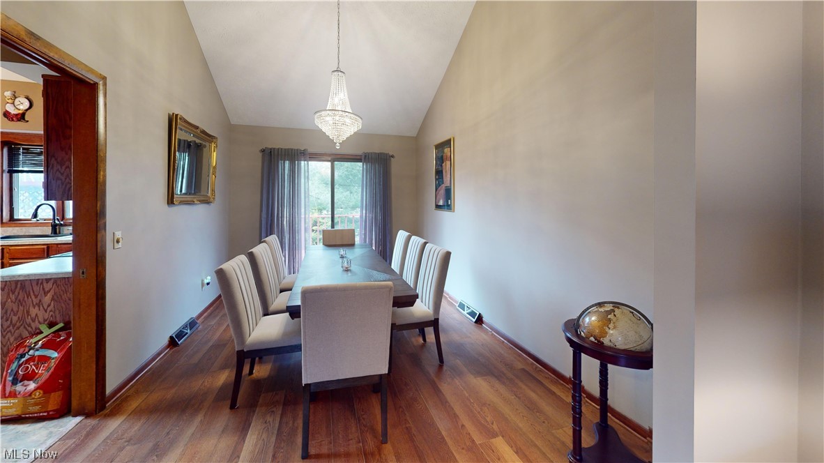 2980 Worrell Road Willoughby, OH 44094 - Photo 15 of 43 Dining area featuring sink, a chandelier, high vaulted ceiling, and dark wood-type flooring