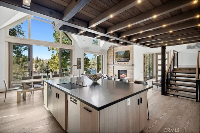 a kitchen with stainless steel appliances granite countertop a sink a counter space wooden floor and a counter top space