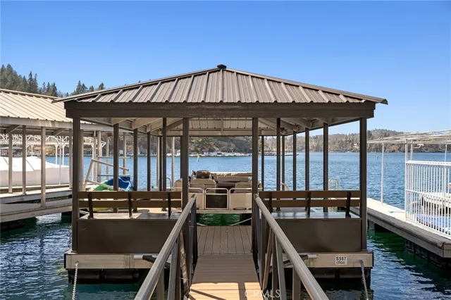 a view of a patio with couches chairs potted plants and wooden floor