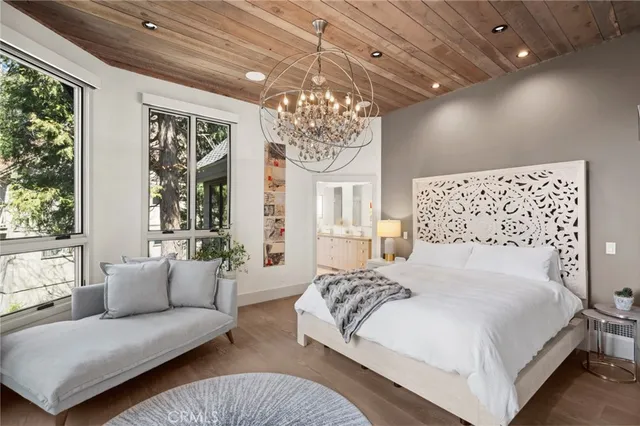 a bedroom with a large bed and a chandelier