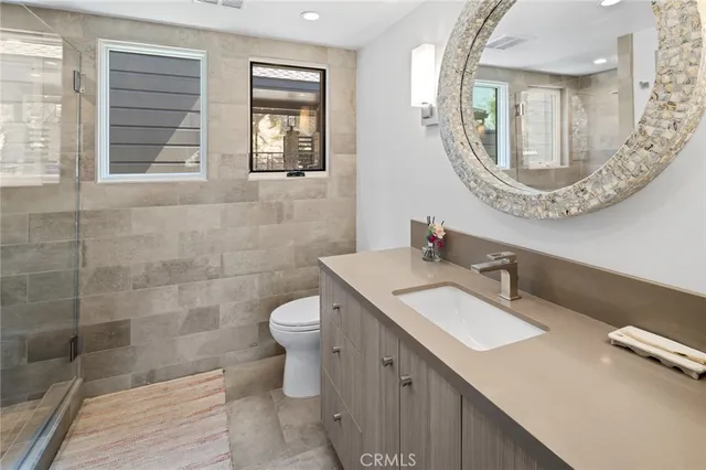 a bathroom with a sink mirror and a toilet