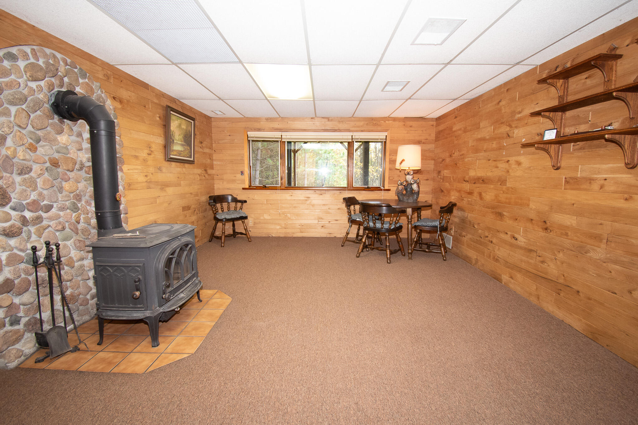 E516 Rustad Road Harrison, WI 54945 - Photo 10 of 52 Hickory lap paneling, Jotel cast iron wood stove with field stone back wall.