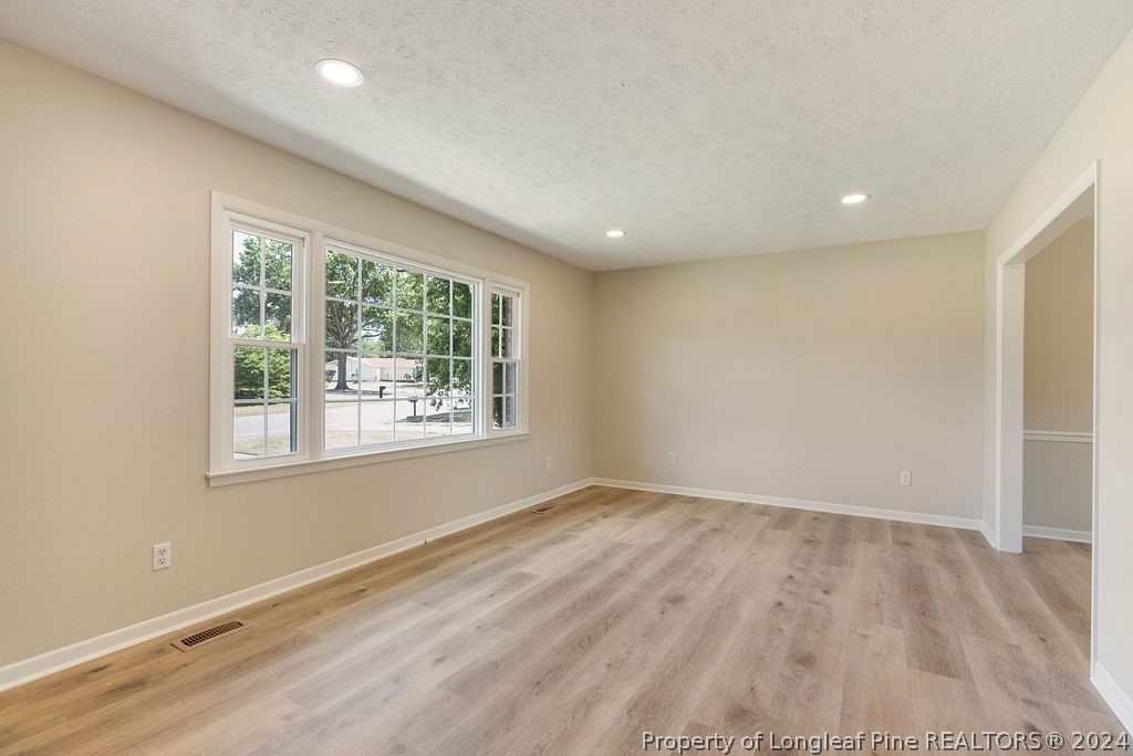 6623 Grist Mill Road Fayetteville, NC 28314 - Photo 4 of 15 an empty room with wooden floor and windows