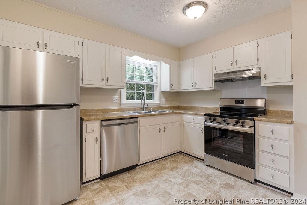 6623 Grist Mill Road Fayetteville, NC 28314 - Photo 5 of 15 a kitchen with granite countertop white cabinets and white appliances