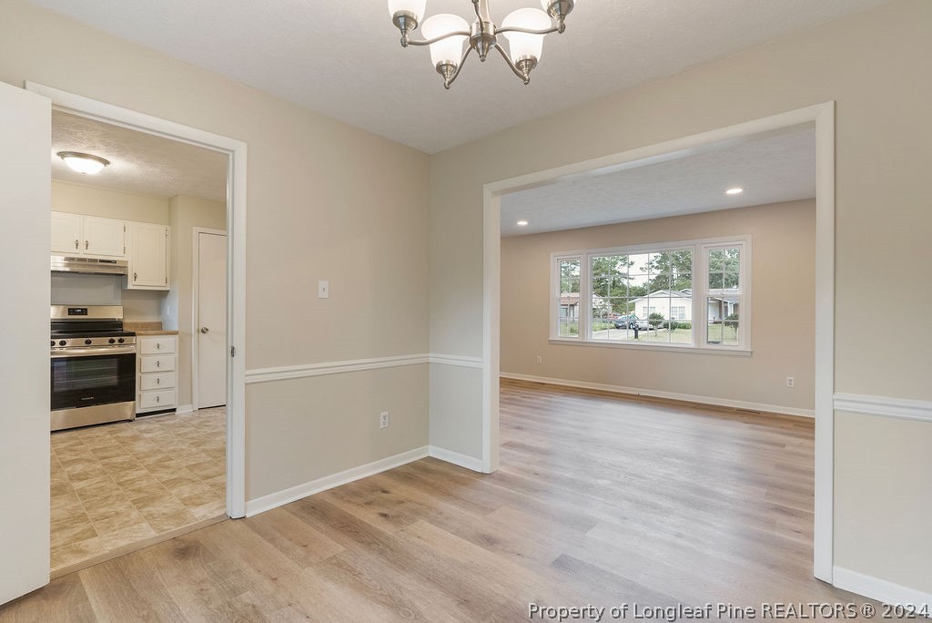 6623 Grist Mill Road Fayetteville, NC 28314 - Photo 6 of 15 an empty room with wooden floor cabinet and windows