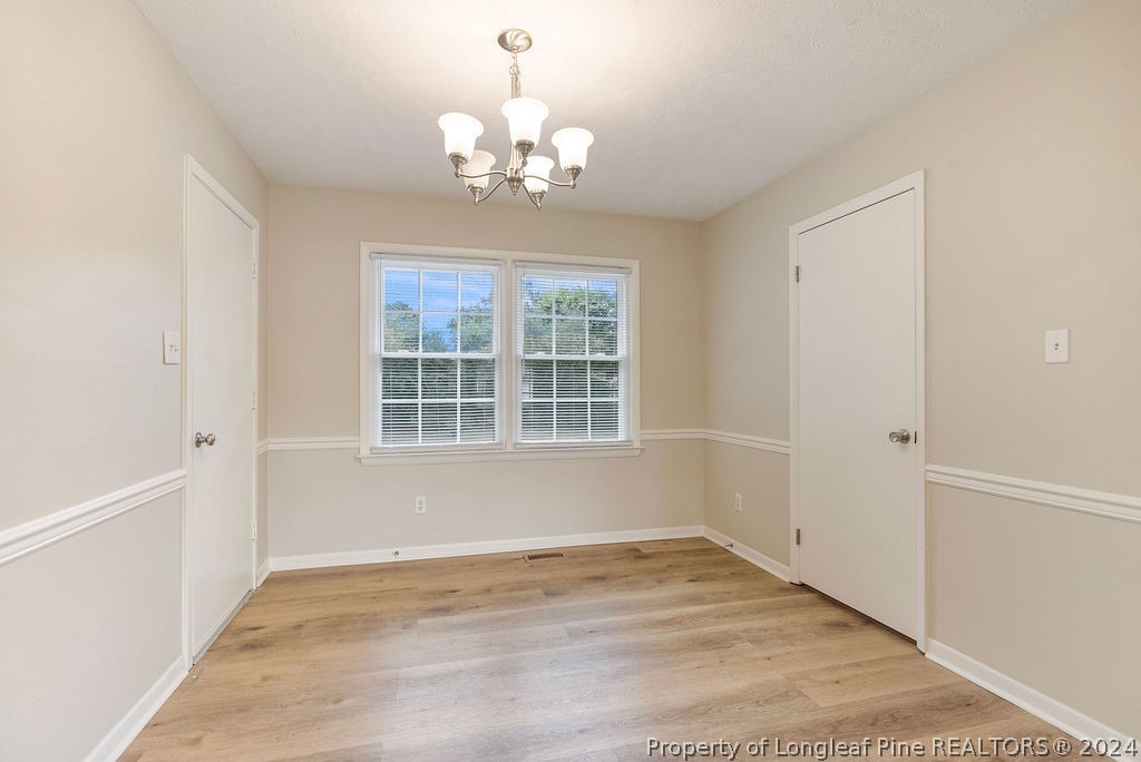 6623 Grist Mill Road Fayetteville, NC 28314 - Photo 7 of 15 a view of an empty room with wooden floor and a window