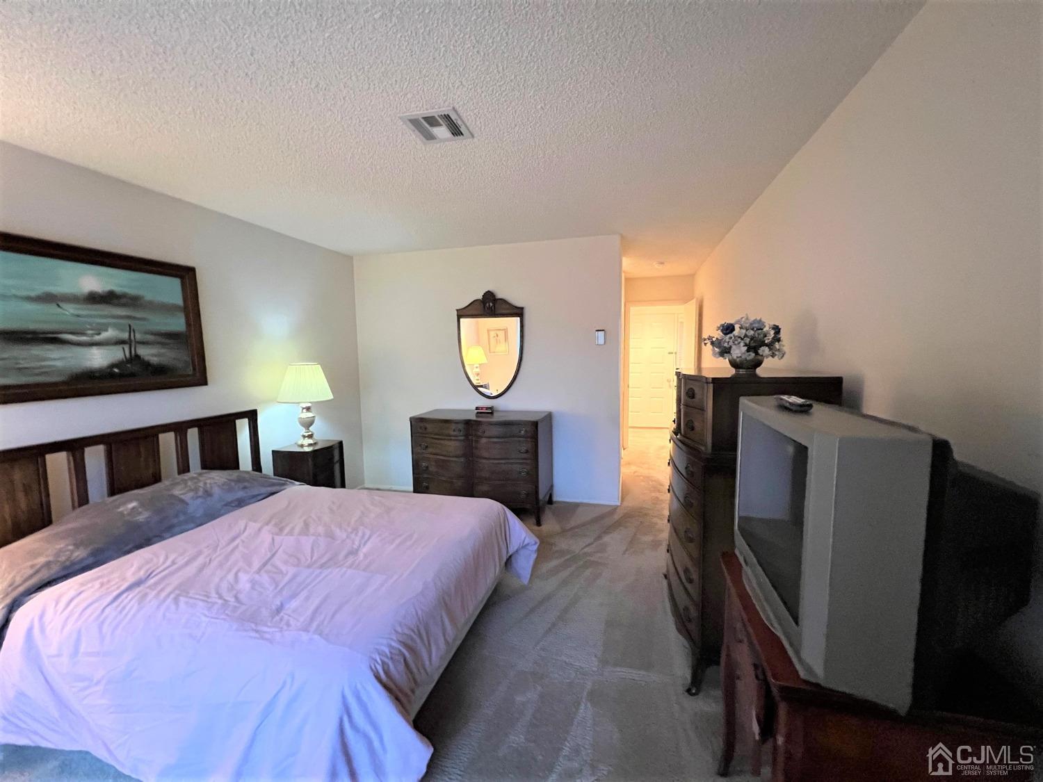 783B Risley Road, Unit A Monroe Township, NJ 08831 - Photo 23 of 30 a bed room with a bed window and a mirror
