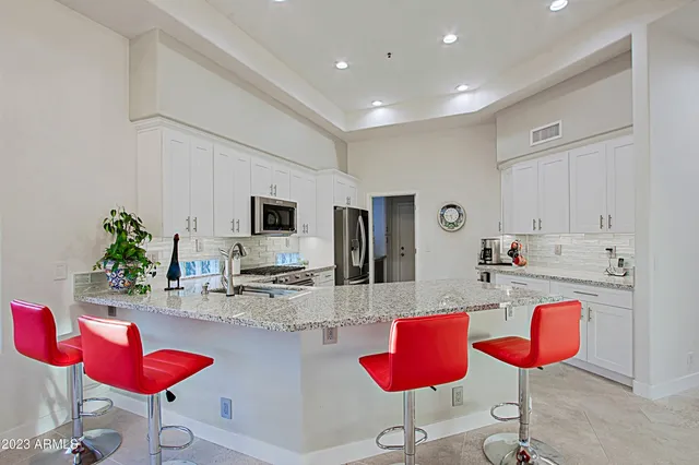 a kitchen with granite countertop cabinets stainless steel appliances and a counter space