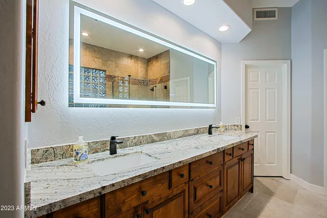 a backyard of a house with table and chairs under an umbrella
