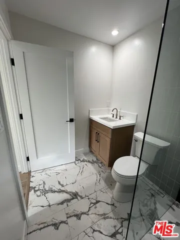 a bathroom with a sink a toilet and a mirror