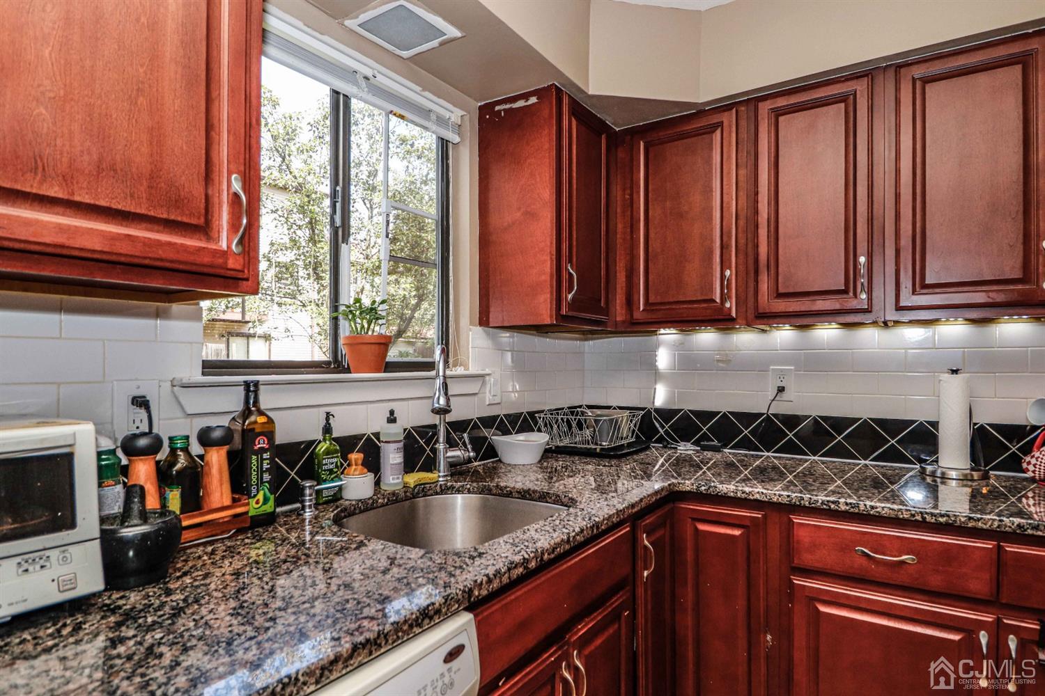 5702 Hana Road Edison, NJ 08817 - Photo 15 of 30 a kitchen with stainless steel appliances granite countertop a sink a stove and a microwave