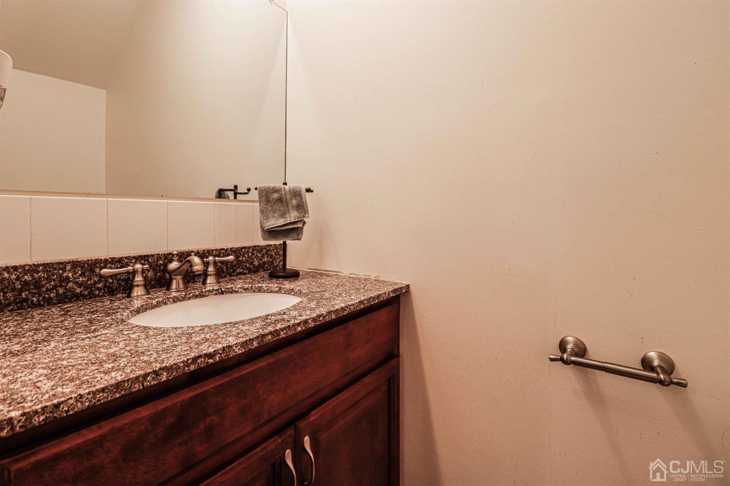 5702 Hana Road Edison, NJ 08817 - Photo 19 of 30 a bathroom with a granite countertop sink and a mirror