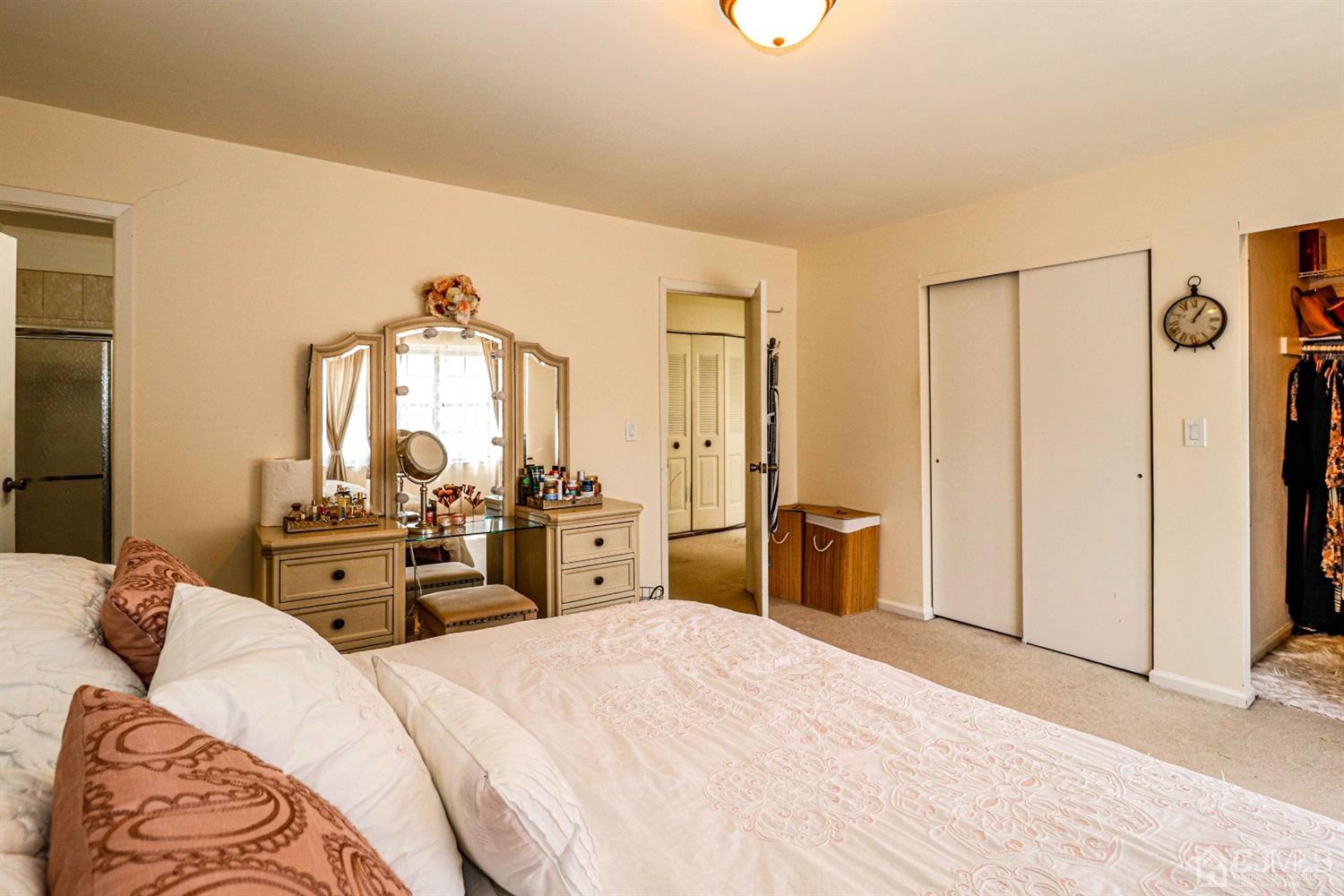 5702 Hana Road Edison, NJ 08817 - Photo 24 of 30 a bedroom with a bed and dresser with mirror