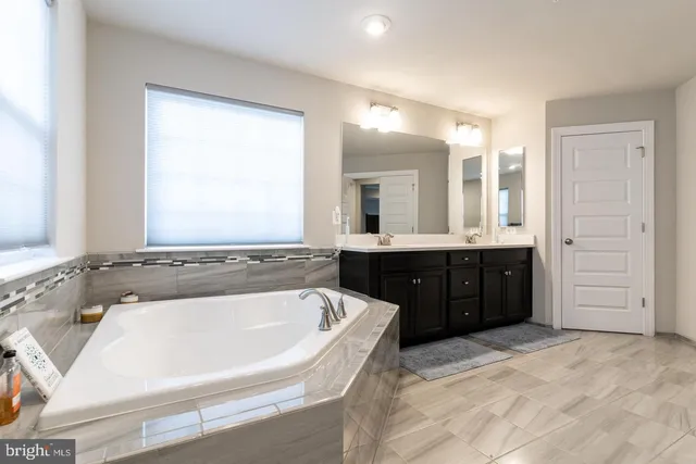 a bathroom with a tub sink and mirror