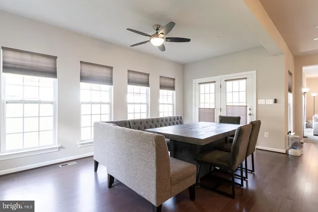 a dining room with wooden floor a chandelier a wooden table and chairs