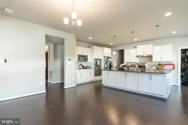 a kitchen with stainless steel appliances granite countertop a refrigerator and a stove