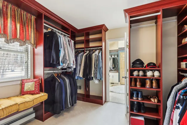 a view of walk in closet with clothes and shoes