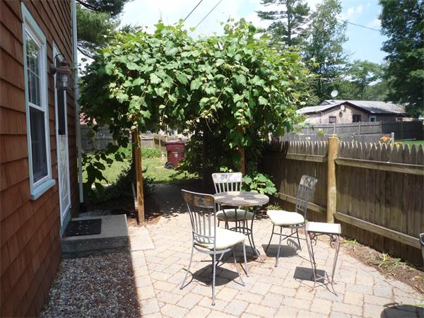 10 Sunset Road Norton, MA 02766 - Photo 22 of 23 a view of a patio with table and chairs potted plants and large tree