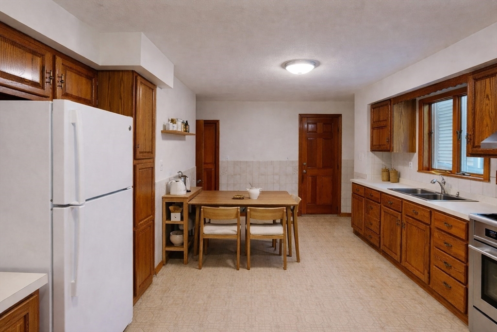 105 Walnut Street, Unit 1 Somerville, MA 02145 - Photo 2 of 14 a large kitchen with a refrigerator a table and chairs in it
