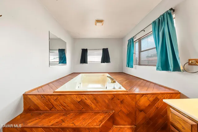 a kitchen with stainless steel appliances granite countertop a lot of cabinets and wooden floor