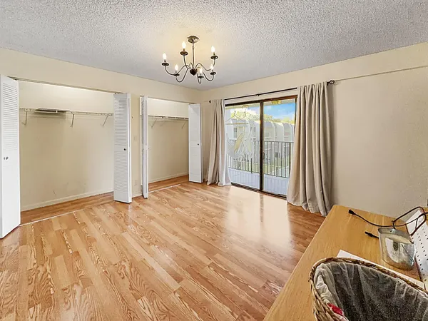 a view of a bedroom with wooden floor and chandelier