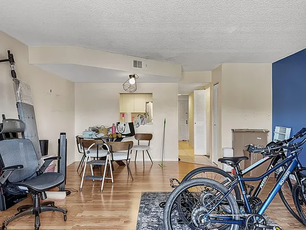 a view of a dining room and livingroom with furniture wooden floor a chandelier