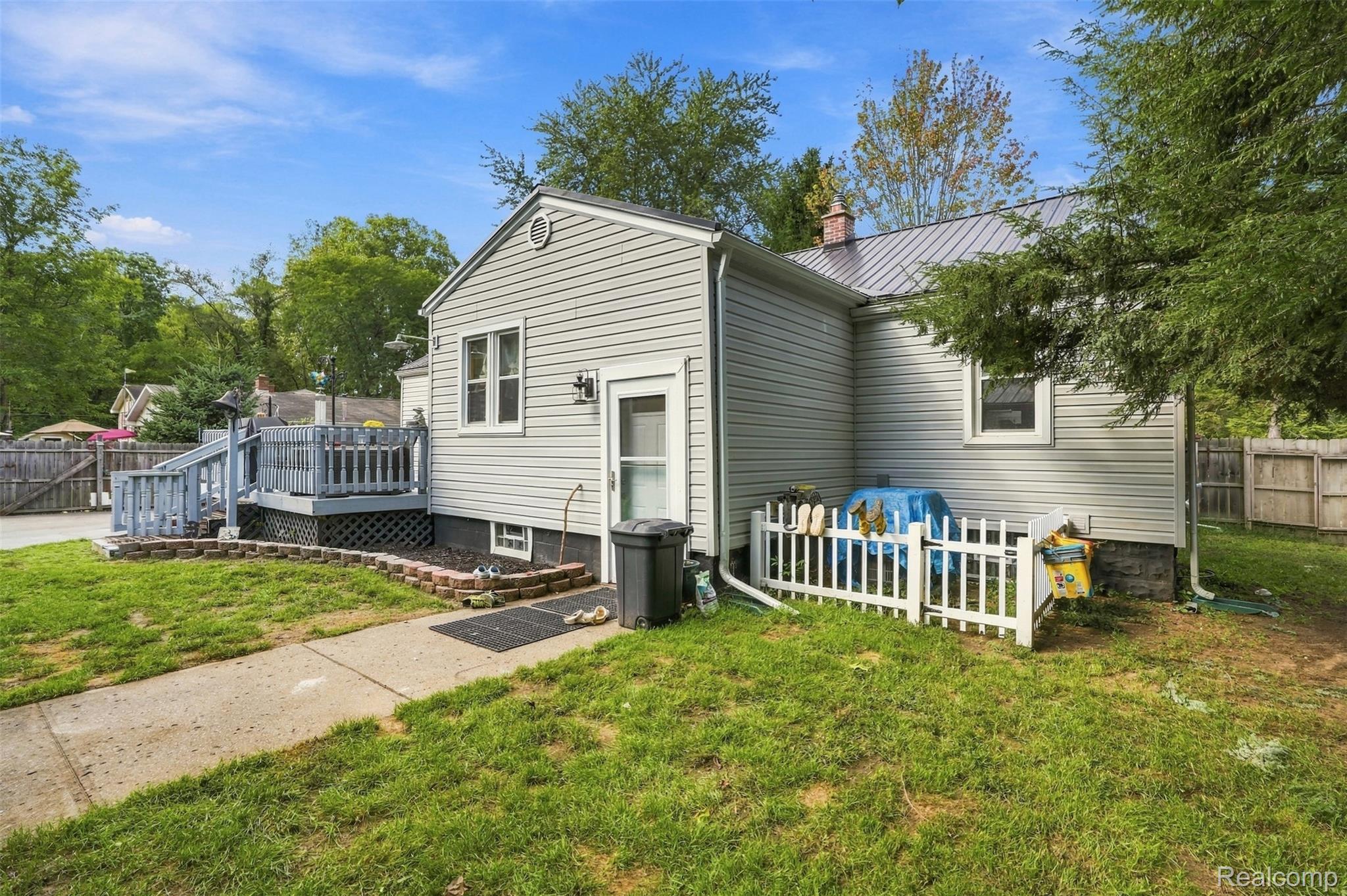 36739 Wick Road Romulus, MI 48174 - Photo 27 of 56 Light gray siding exterior with a metal roof