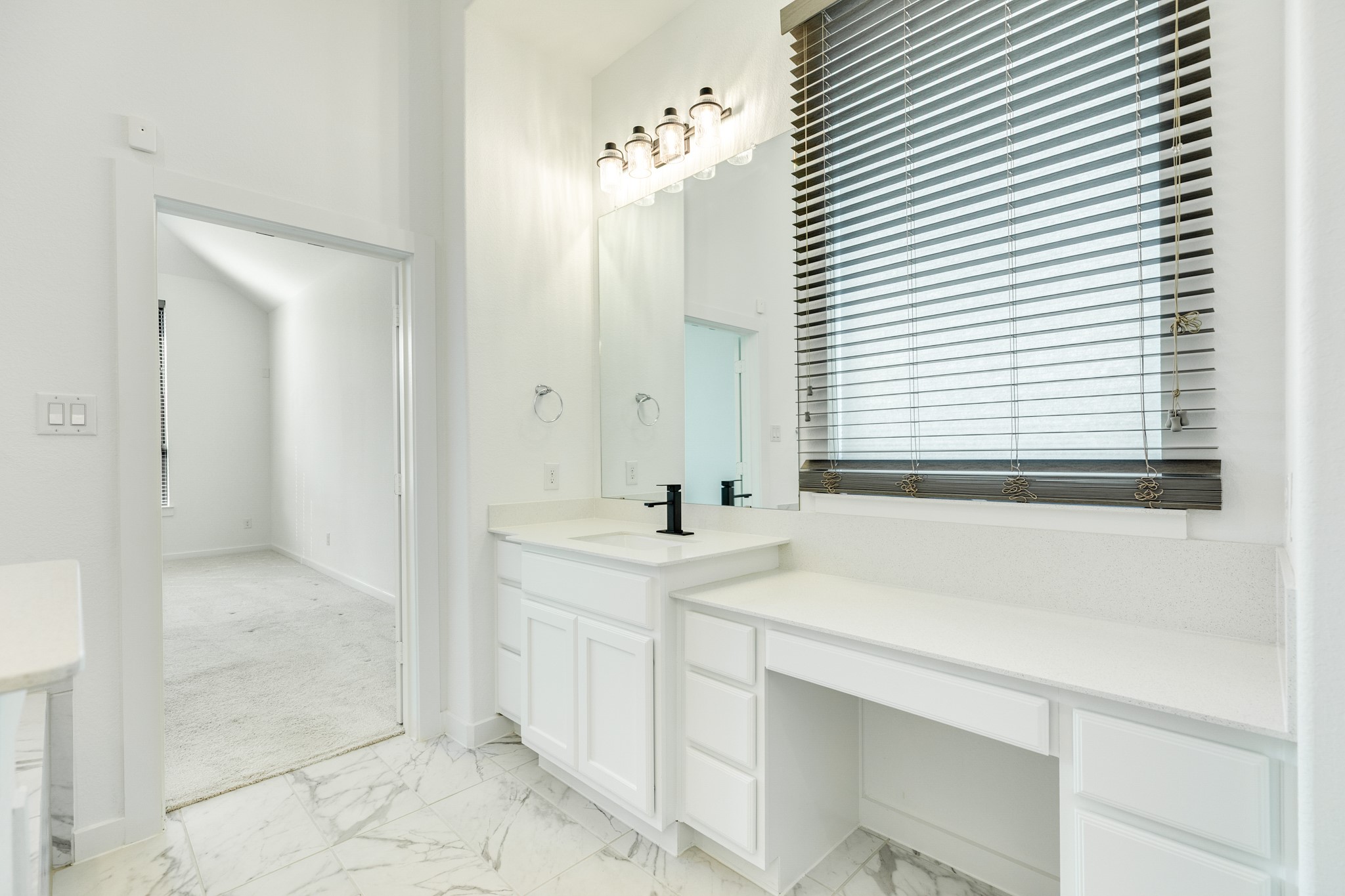 3806 Shackleton Court Rosharon, TX 77583 - Photo 28 of 50 Primary bath boasts excellent lighting, featuring a window that overlooks the makeup/dressing area, providing ample natural light. The spacious layout comfortably accommodates a chair or stool, and the bathroom itself is very roomy.