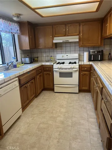a kitchen with a stove sink and cabinets
