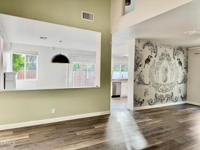 an empty room with wooden floor and mirror