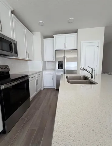 a kitchen with stainless steel appliances a stove sink and refrigerator