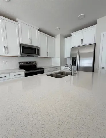 a kitchen with stainless steel appliances a microwave a sink and a refrigerator