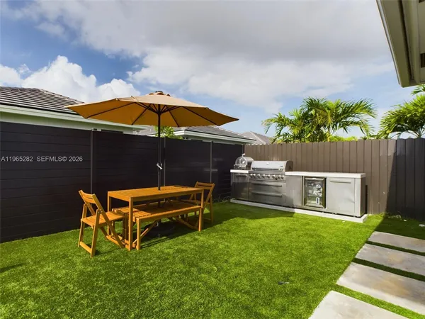 a backyard of a house with table and chairs