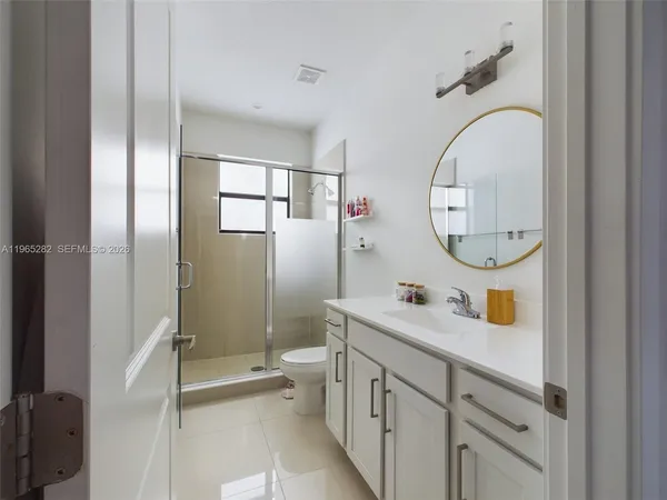 a bathroom with a double vanity sink mirror and toilet
