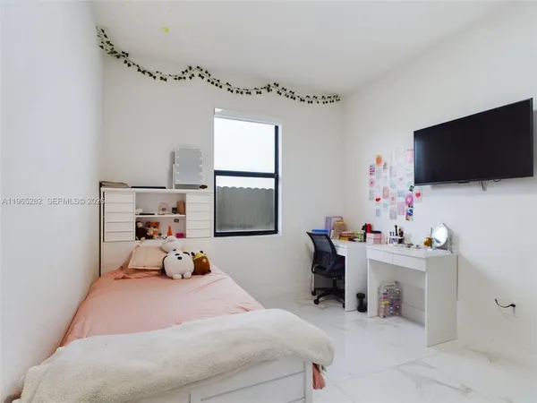 a bedroom with a bed a flat screen tv and a couch