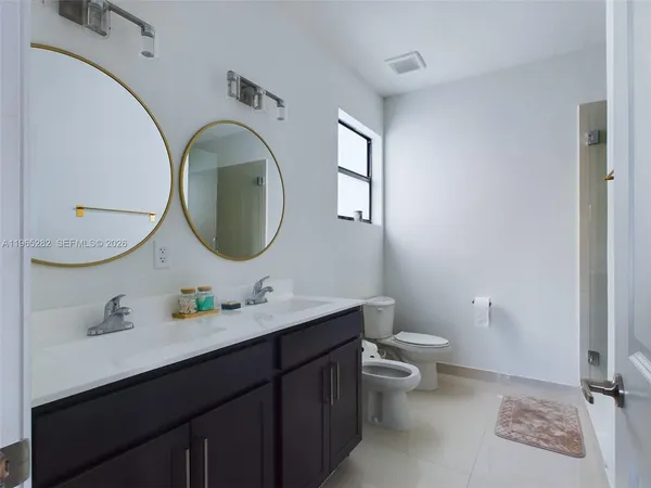 a bathroom with a toilet a sink and mirror