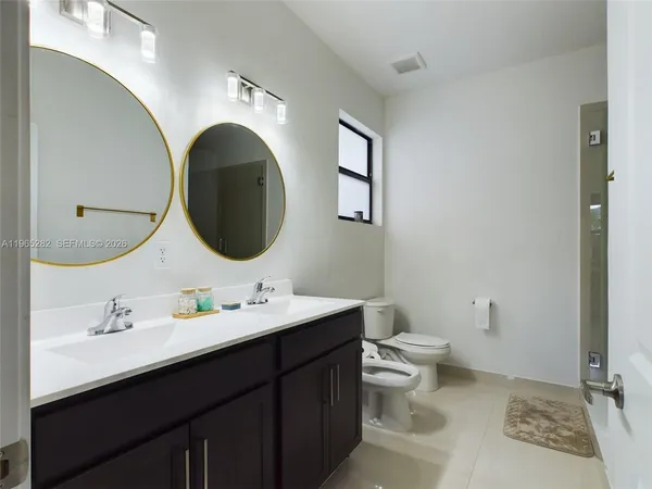 a bathroom with a toilet a sink and mirror