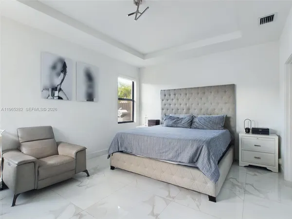 a bedroom with a bed couch and window