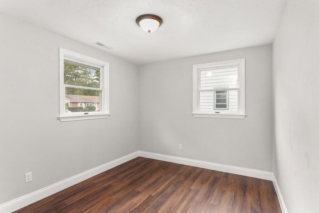 14 Fairbrook Road Framingham, MA 01701 - Photo 21 of 24 an empty room with wooden floor and windows