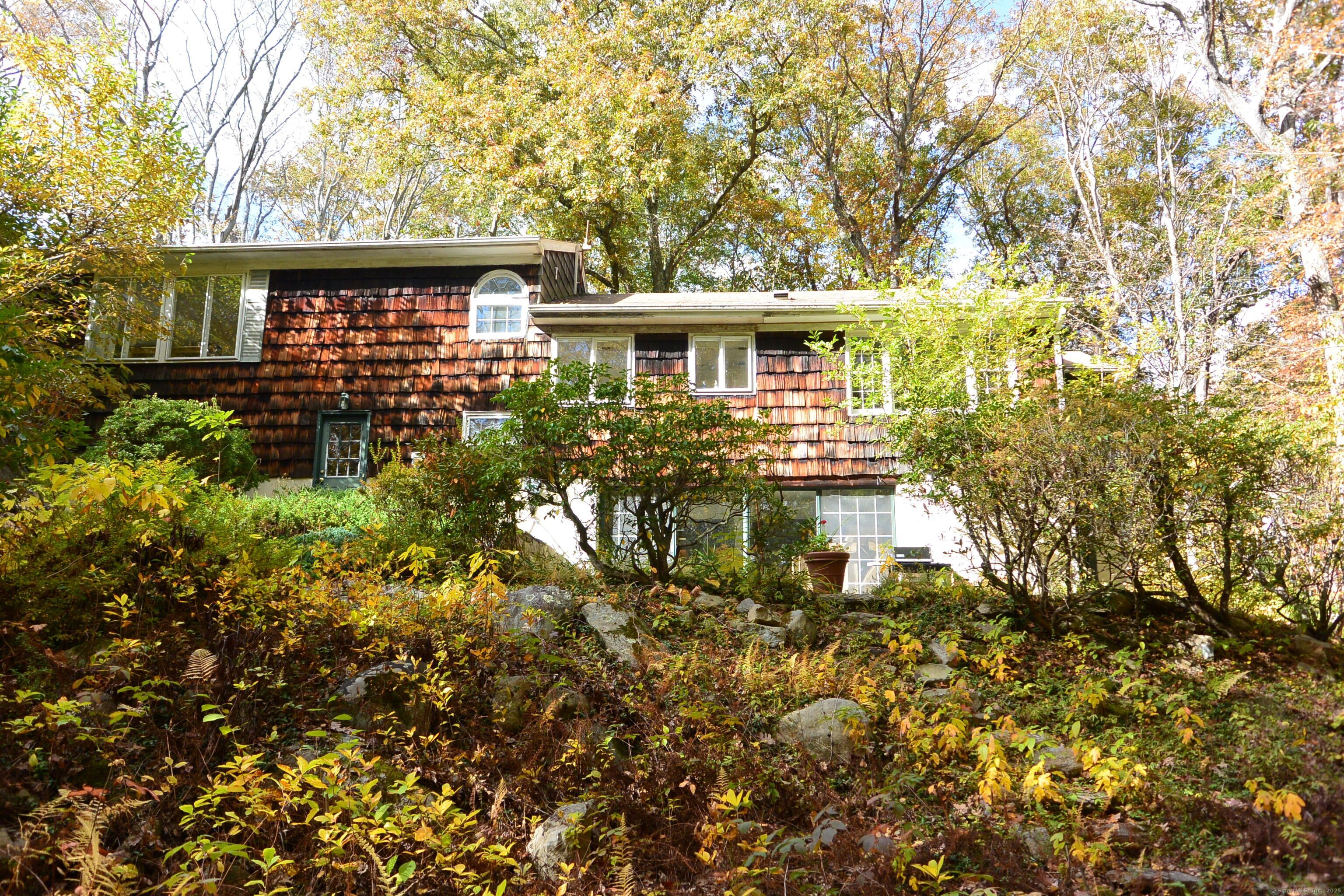 439 Cheese Spring Road New Canaan, CT 06840 - Photo 28 of 36 a front view of a house with a garden