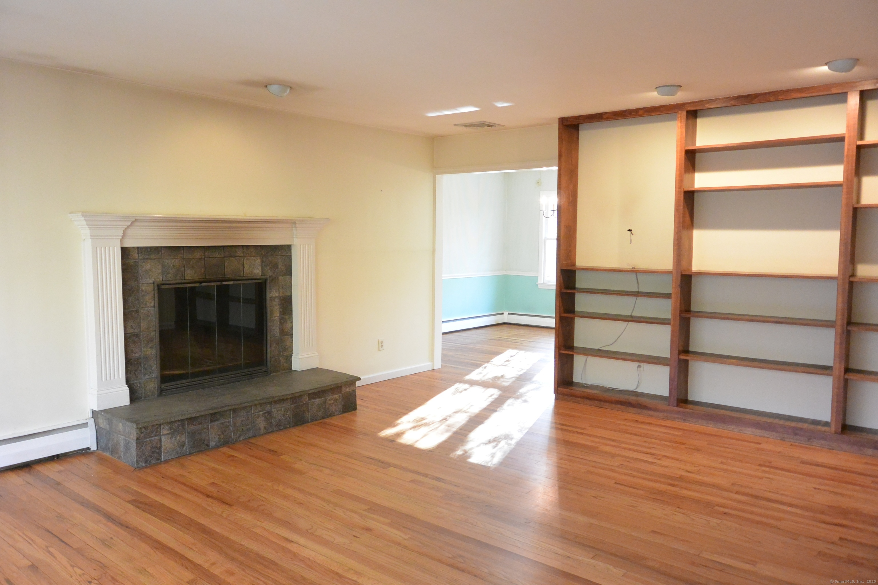439 Cheese Spring Road New Canaan, CT 06840 - Photo 4 of 36 a view of an empty room with wooden floor fireplace and a window
