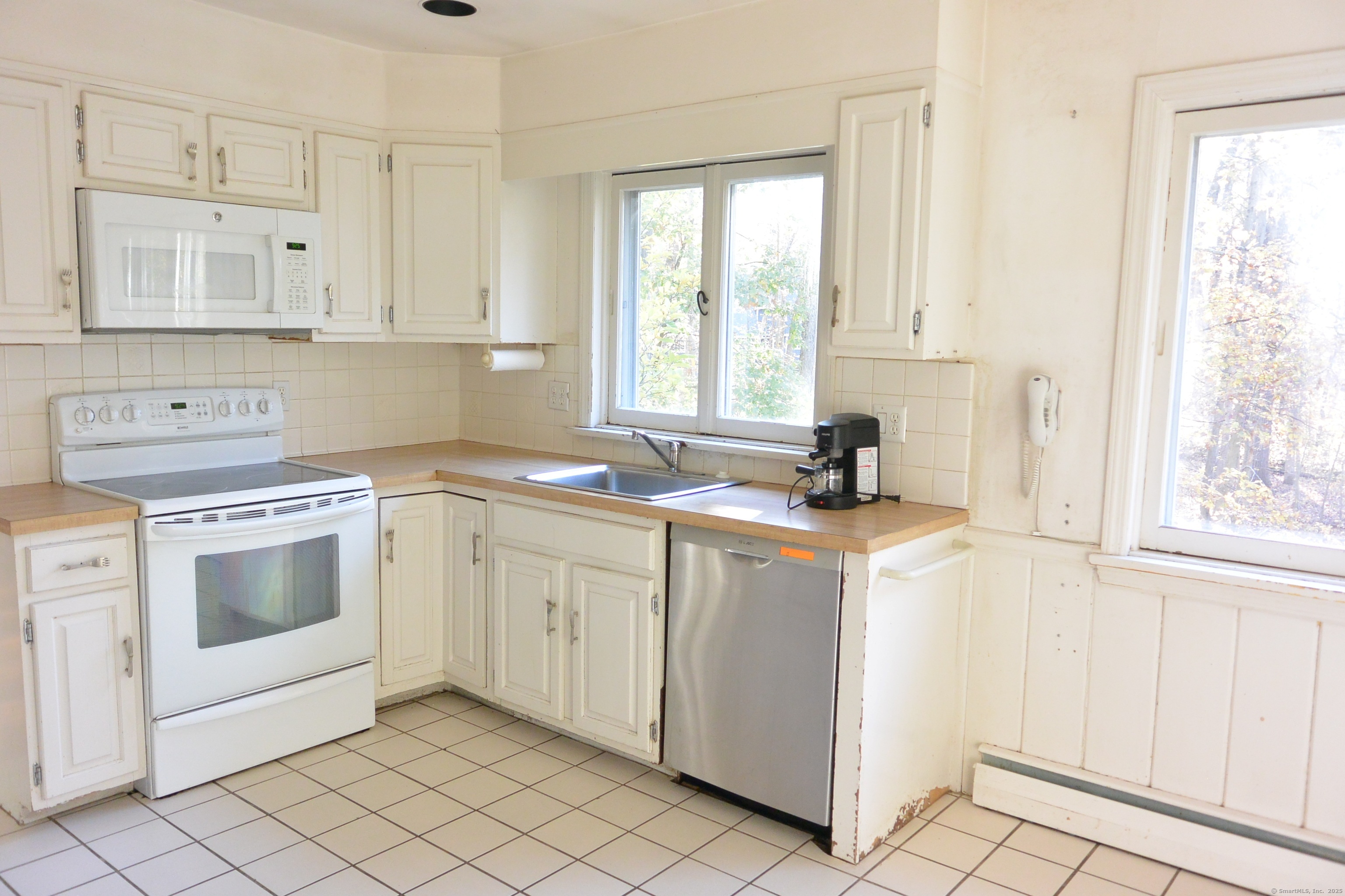 439 Cheese Spring Road New Canaan, CT 06840 - Photo 8 of 36 a kitchen with white cabinets and white appliances