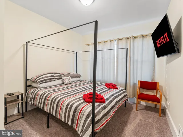 a bedroom with a bed and a flat screen tv