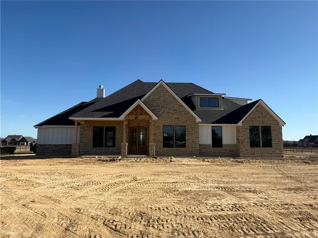 a front view of a house with a yard covered with snow