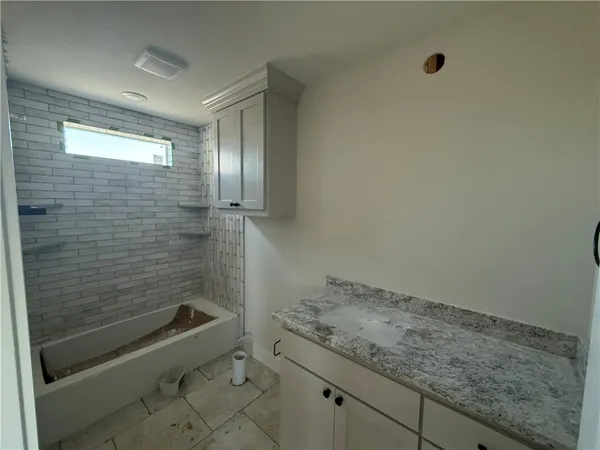 a bathroom with a granite countertop sink a toilet and shower